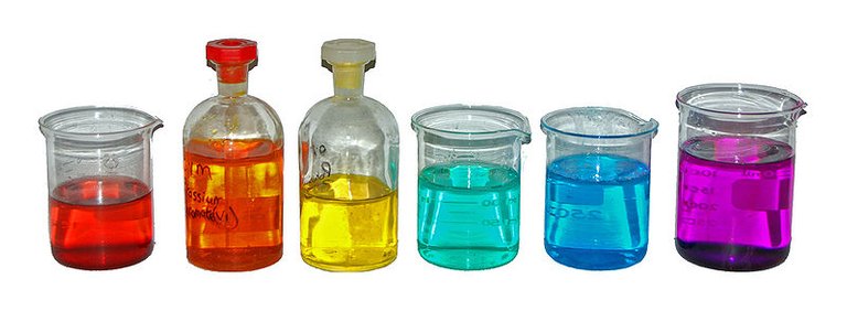 From left to right, aqueous solutions of: Co(NO3)2 (red); K2Cr2O7 (orange); K2CrO4 (yellow); NiCl2 (turquoise); CuSO4 (blue); KMnO4 (purple).