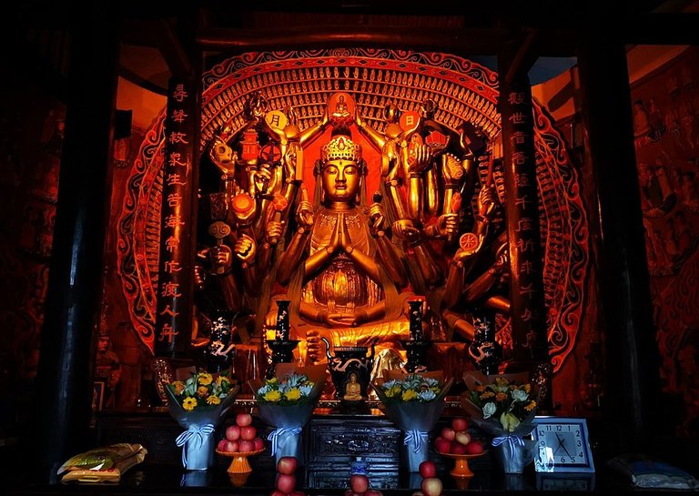 Shrine to a Tang dynasty (896 AD) stone statue of the Thousand-Armed Guanyin (千手觀音 Qianshou Guanyin) in Shengshui Temple (內江聖水寺 Neijiang Shengshui-si) in Neijiang, Sichuan, China Picture. - Nyarlathotep1001, CC BY-SA 4.0, via Wikimedia Commons.
