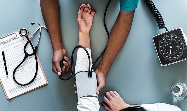 A healthcare professional performing blood pressure monitoring on a patient.