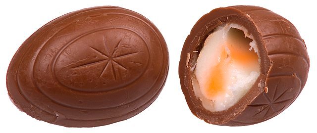 A whole and split Cadbury Creme Egg.