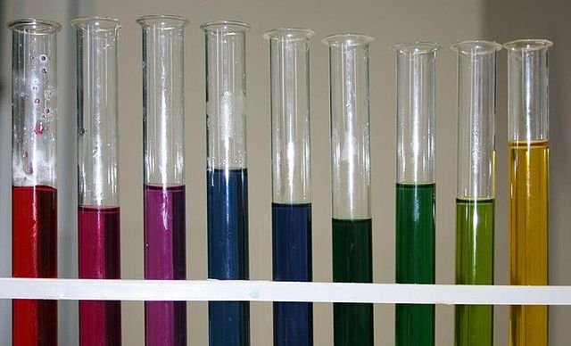 A gradient of red cabbage extract pH indicator from acidic solution on the left to basic on the right