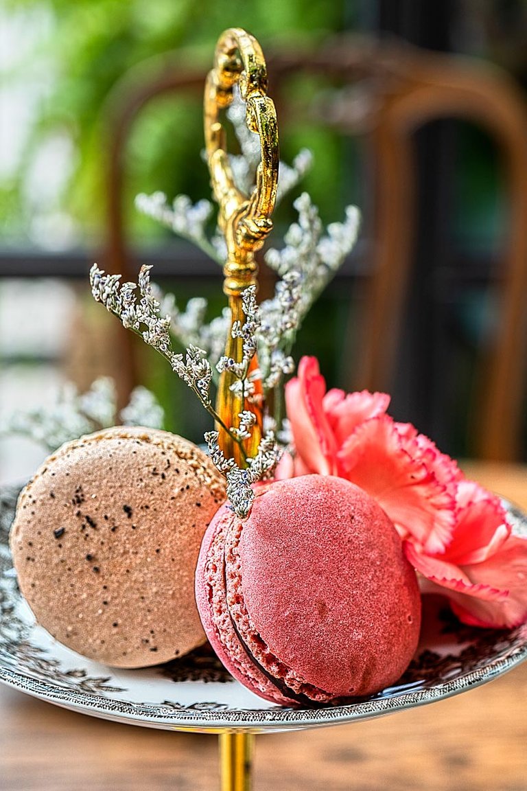 earl gray macaron and raspberry macaron with a flower a beautiful macaron presentation.