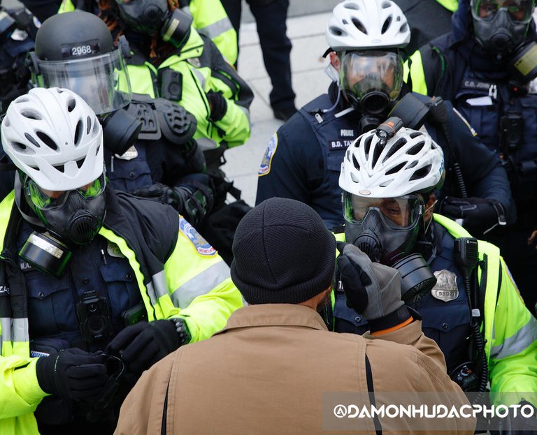 Angry citizen confronts a line of riot police.