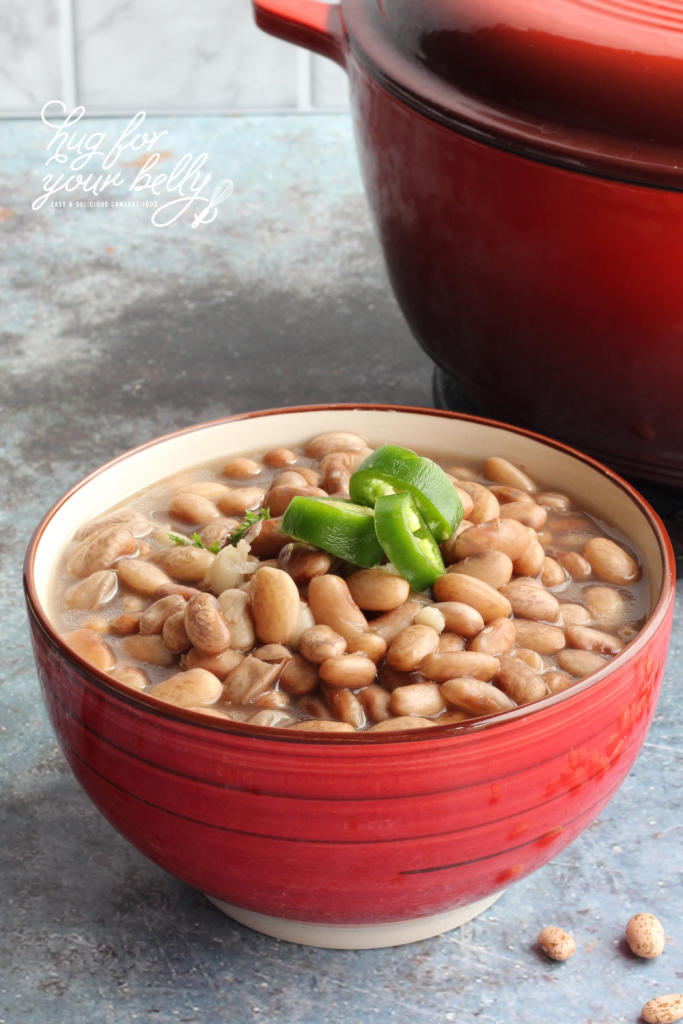 beans in red bowl with jalapeno slices on top