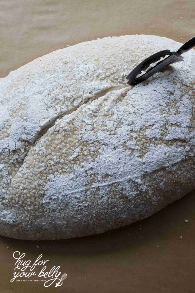 lame cutting into sourdough bread dough