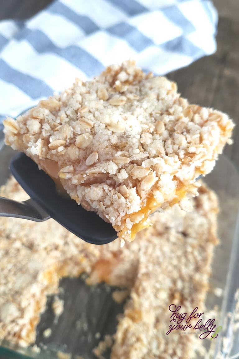 apricot oat bar being lifted out of the pan with a spatula