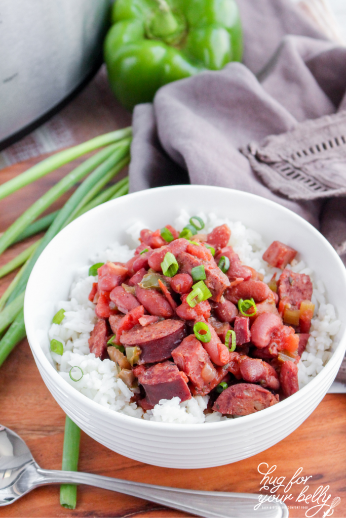 red beans and rice in white bowl next to spoon