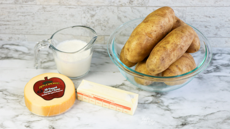 potatoes, butter, milk, and gouda cheese on marble background