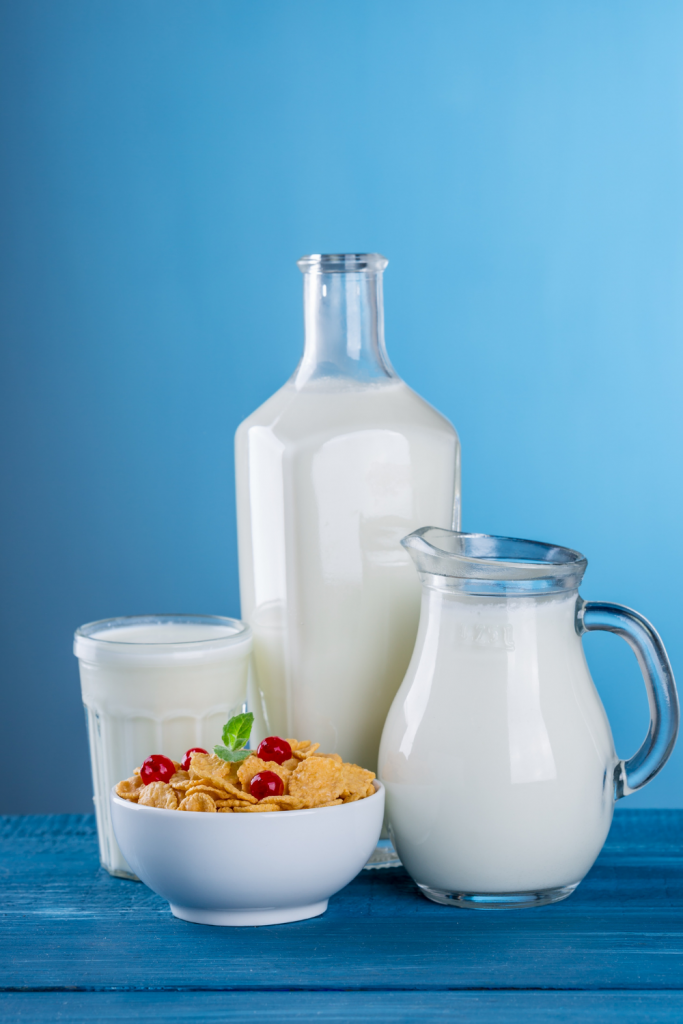 milk in jar, glass by bowl of cereal