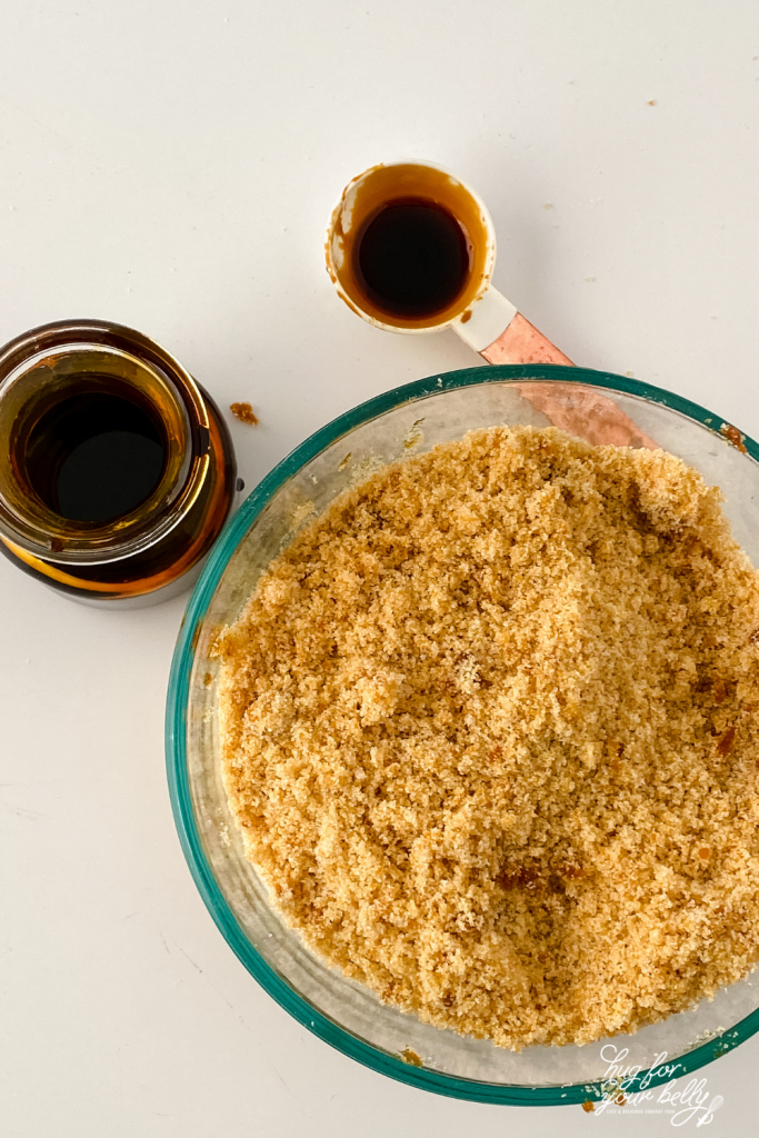 brown sugar in bowl next to jar of molasses and measuring spoon 