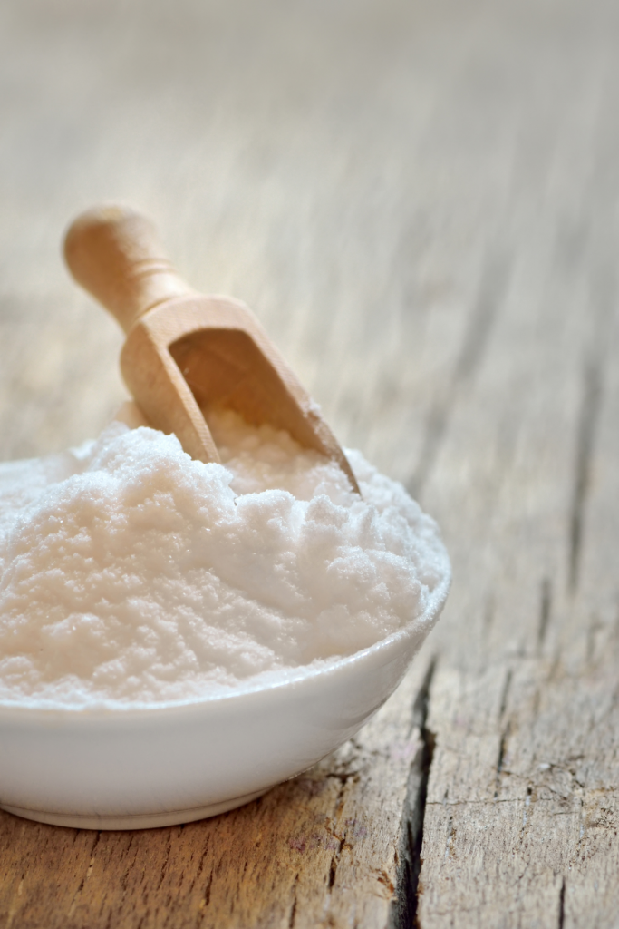 baking powder in white bowl with wooden scoop