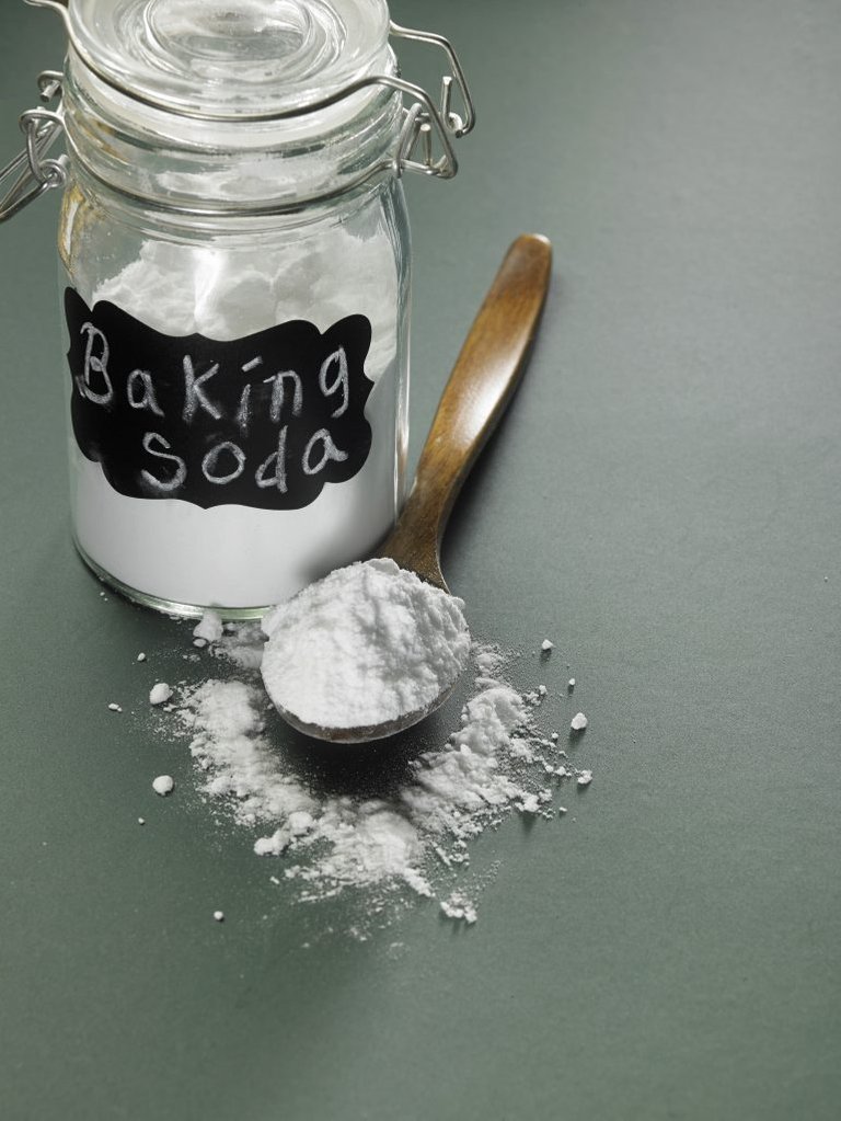 baking soda next to jar and on a wooden spoon