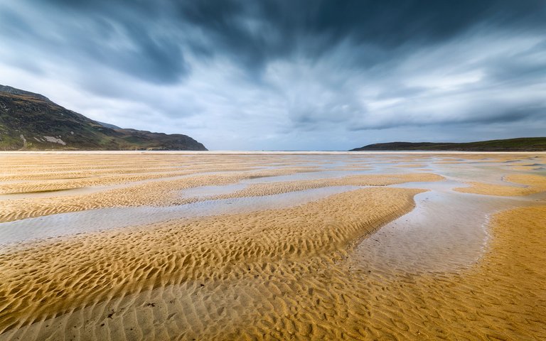 At low tide, Maghera Beach shows endless patterns or tidal pools and sand.