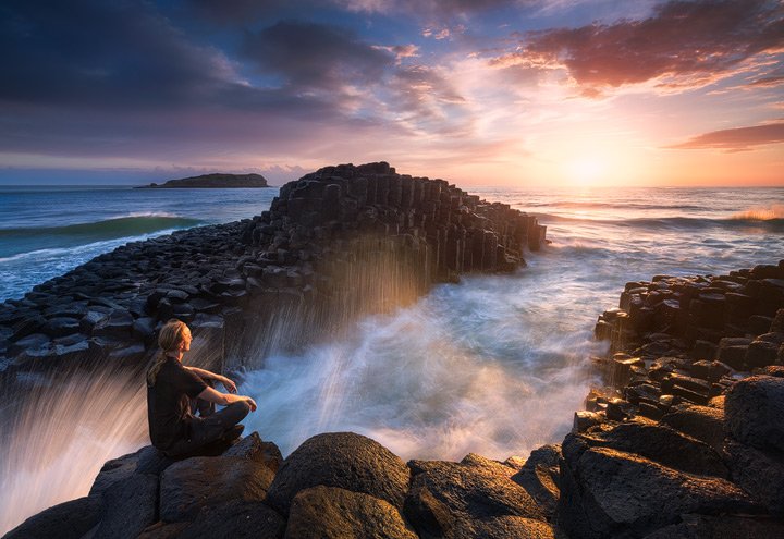 A person meditating on the rocks of Fingal head