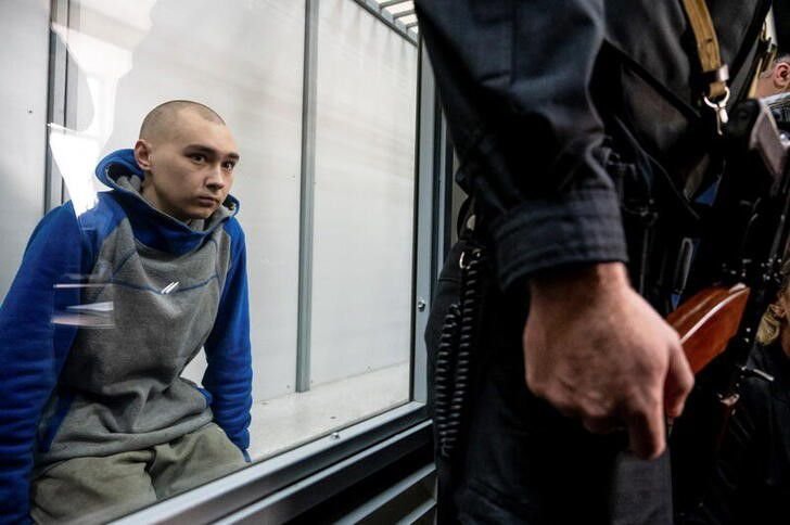 Russian soldier Vadim Shishimarin, 21, suspected of violations of the laws and norms of war, sits inside a defendants' cage during a court hearing, amid Russia's invasion of Ukraine, in Kyiv, Ukraine May 13, 2022. REUTERS/Viacheslav Ratynskyi