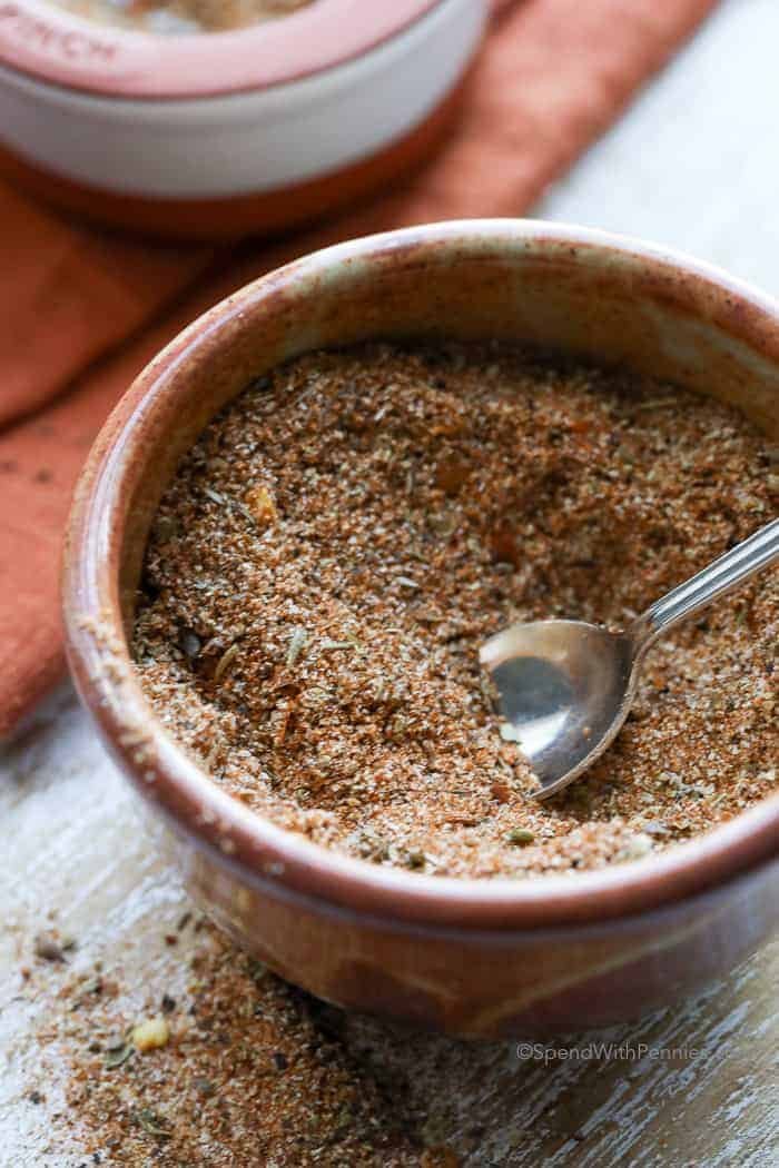 A bowl of homemade cajun seasoning with a small spoon in it