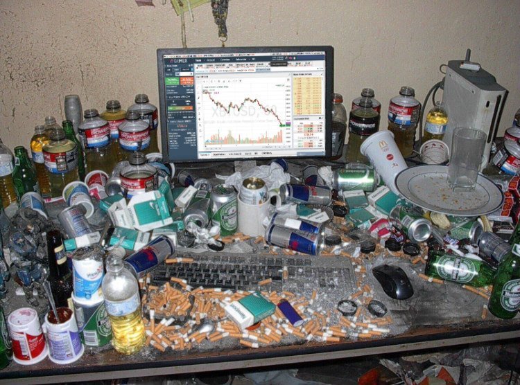Computer desk covered with cigarette butts, ash, empty cans and plastic jars, and what looks like open piss bottles. The screen shows XBTUSD going down on BitMex.
