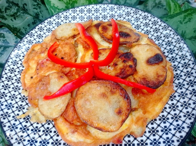 Rich omelet with potato slices and red bell pepper