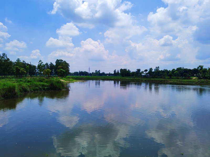 Cloudy sky visible on the banks of the Ghagat River. Some beautiful reflections are a unique gesture of nature.