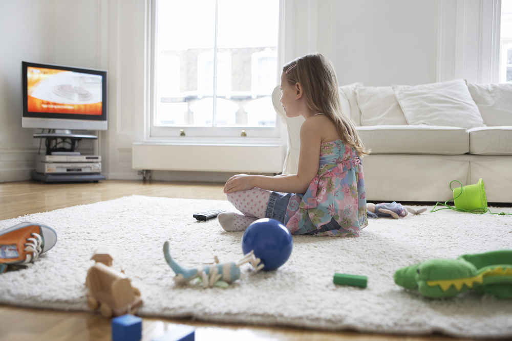 little-girl-watching-TV-with-her-toys-on-the-floor.jpg