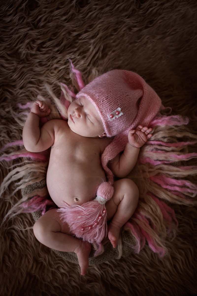 cute-sleeper-newborn-baby-girl-in-pink-cap-on-wool.jpg