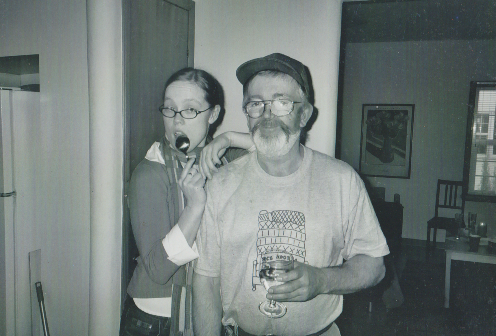2004-12 - Arnold Family Reunion - Katie with a spoon with Don, her dad, in black and white.png