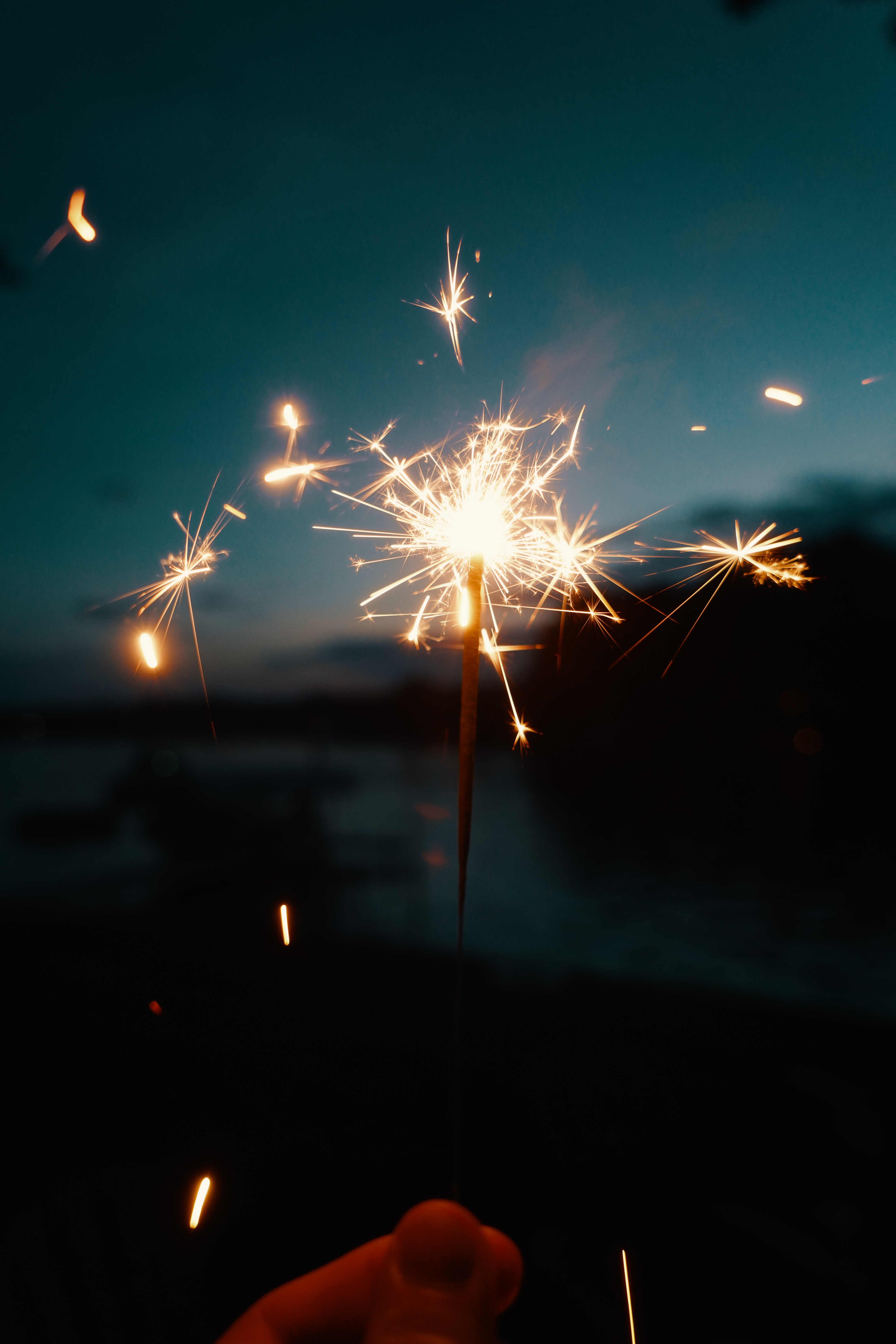 person-holding-bengal-lights-or-sparklers-on-dark-blurry-background.jpg