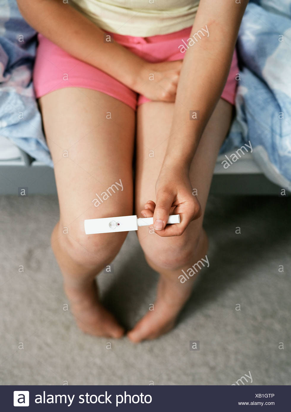 teenage-girl-holding-pregnancy-test-XB1GTP.jpg