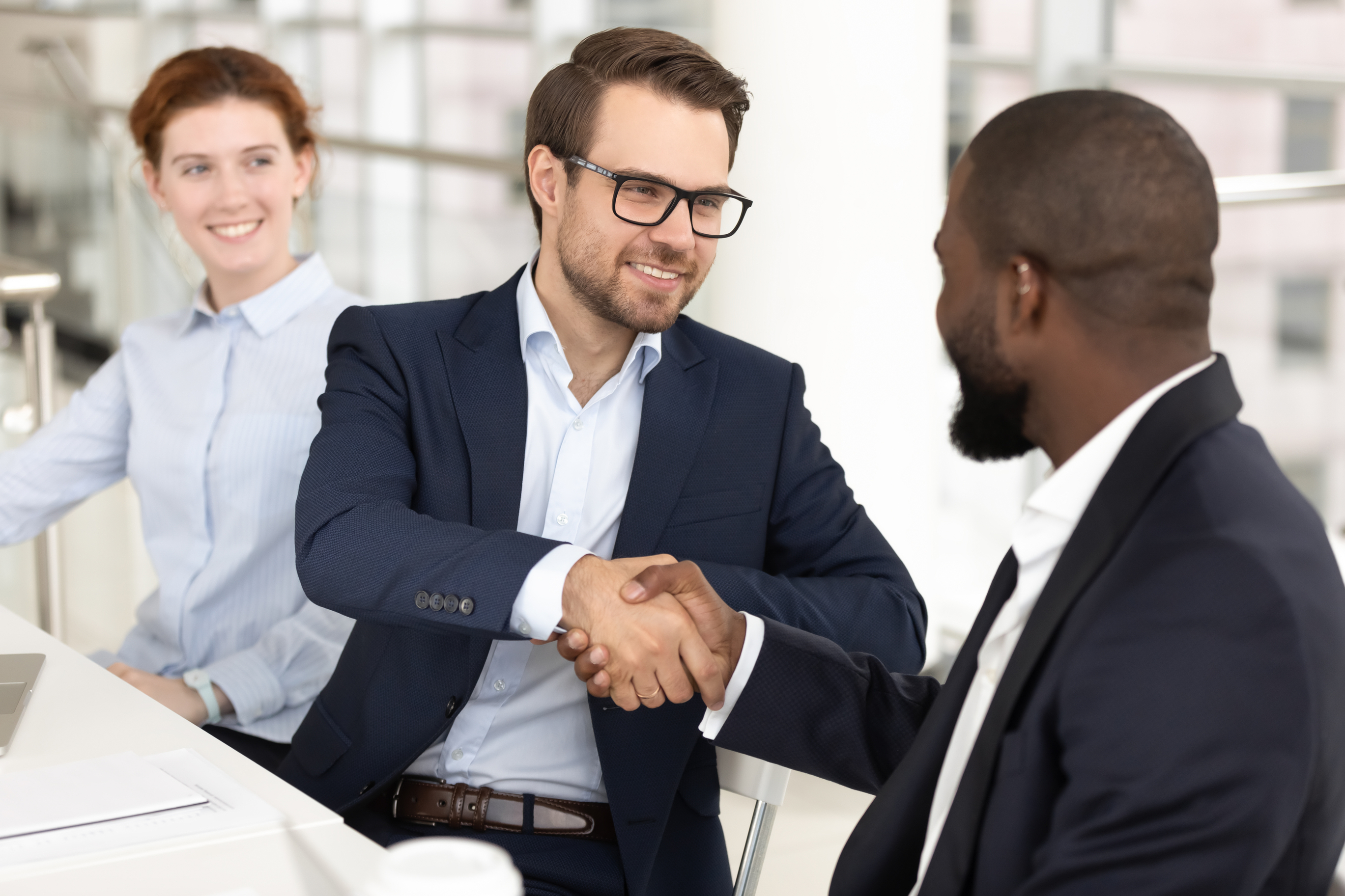 smiling-white-man-handshaking-african-american-businessman-at-meeting-174208203.jpg