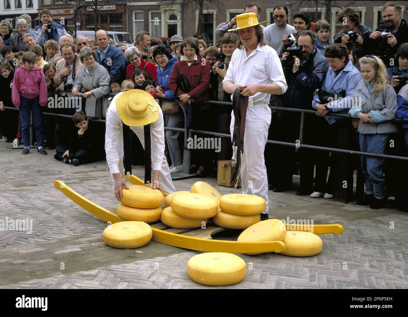 la-atraccion-turistica-de-alkmaar-el-mercado-del-queso-en-la-plaza-del-mercado-de-alkmaar-dos-corredores-vestidos-tradicionalmente-con-las-tablas-de-queso-traduccion-automatica-2fnf5eh.jpg