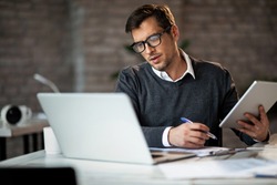 stock-photo-multi-tasking-businessman-working-in-the-office-he-is-using-touchpad-while-reading-an-e-mail-on-1350370946.jpg