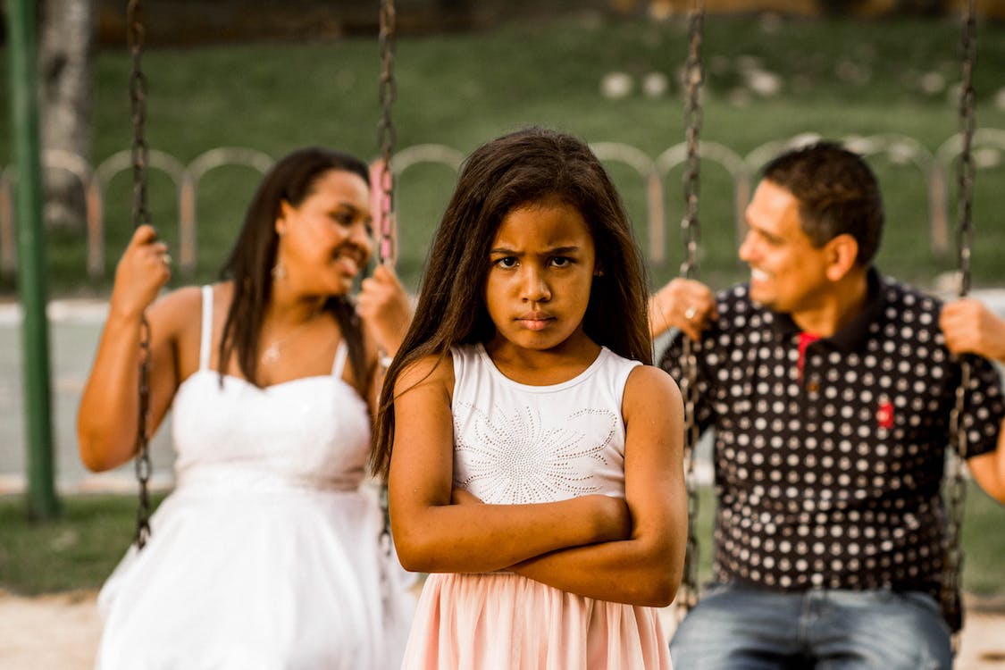 free-photo-of-sulky-young-girl-in-front-of-swing-occupied-by-smiling-grown-ups.jpeg