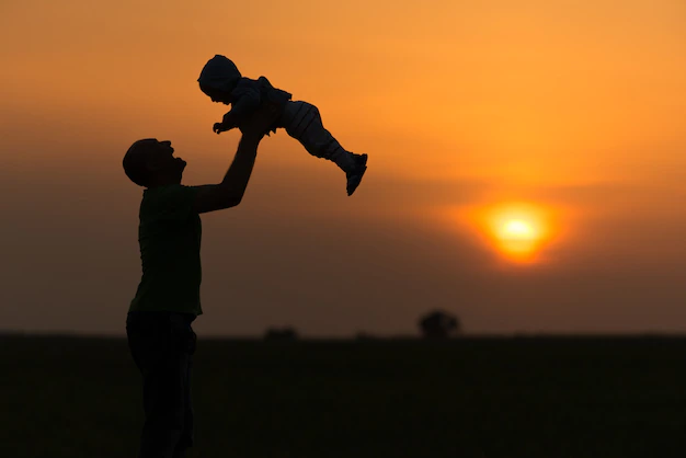 happy-dad-throws-baby-sunset_186202-3190.webp