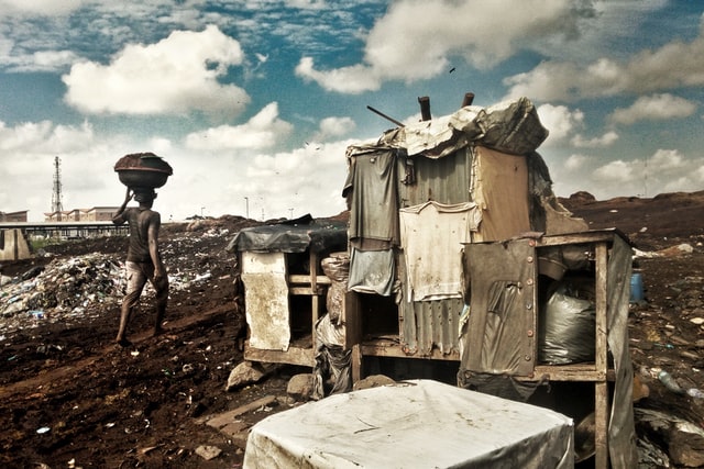 A man carrying a head pan next to a makeshift Locker Lagos, Nigeria