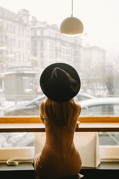 woman-in-black-hat-sitting-in-front-of-glass-window-3681653.jpg