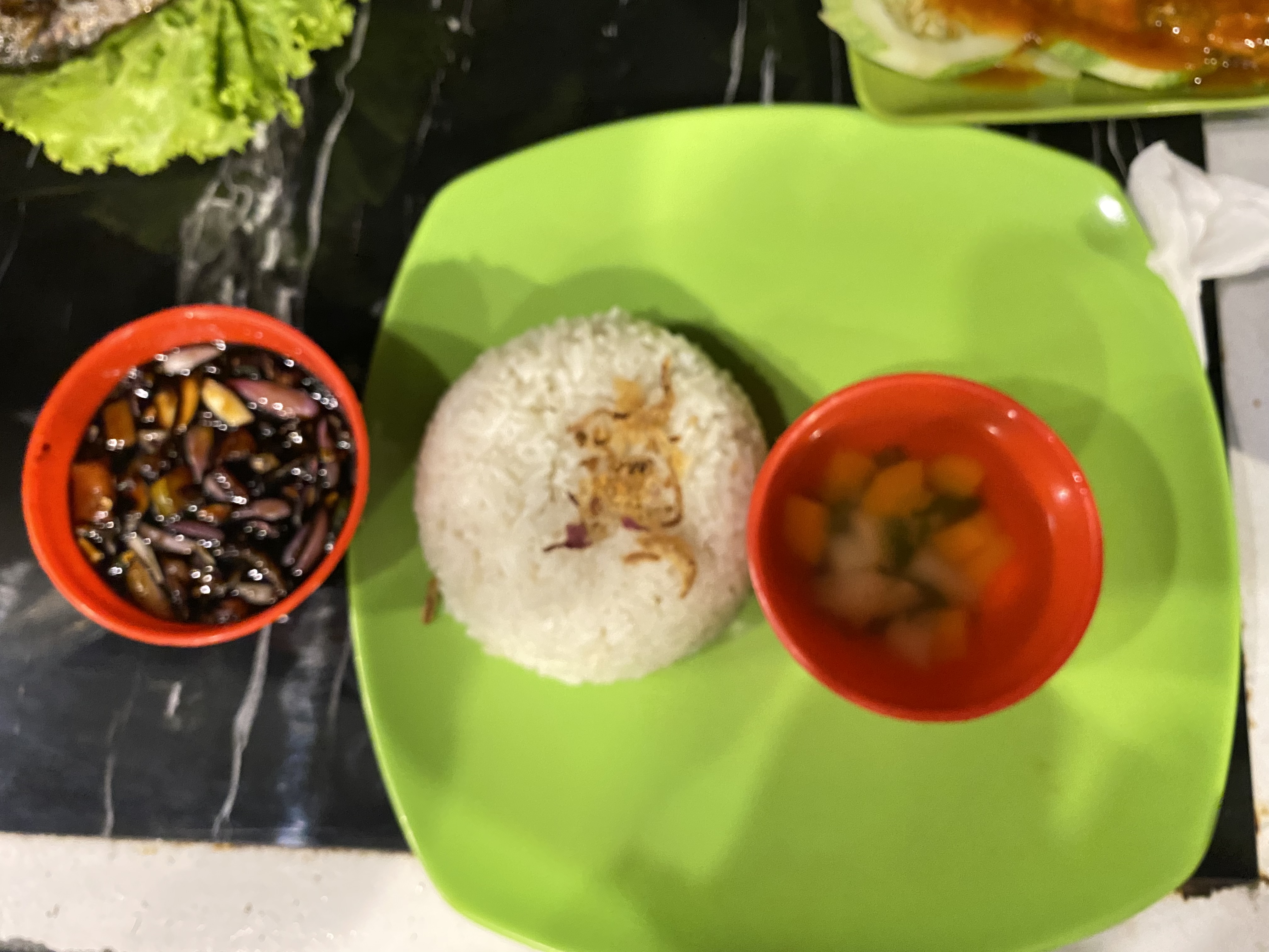 Dinner with rice and soy sauce with chopped chilies, onions, tomatoes for grilled fish salad.