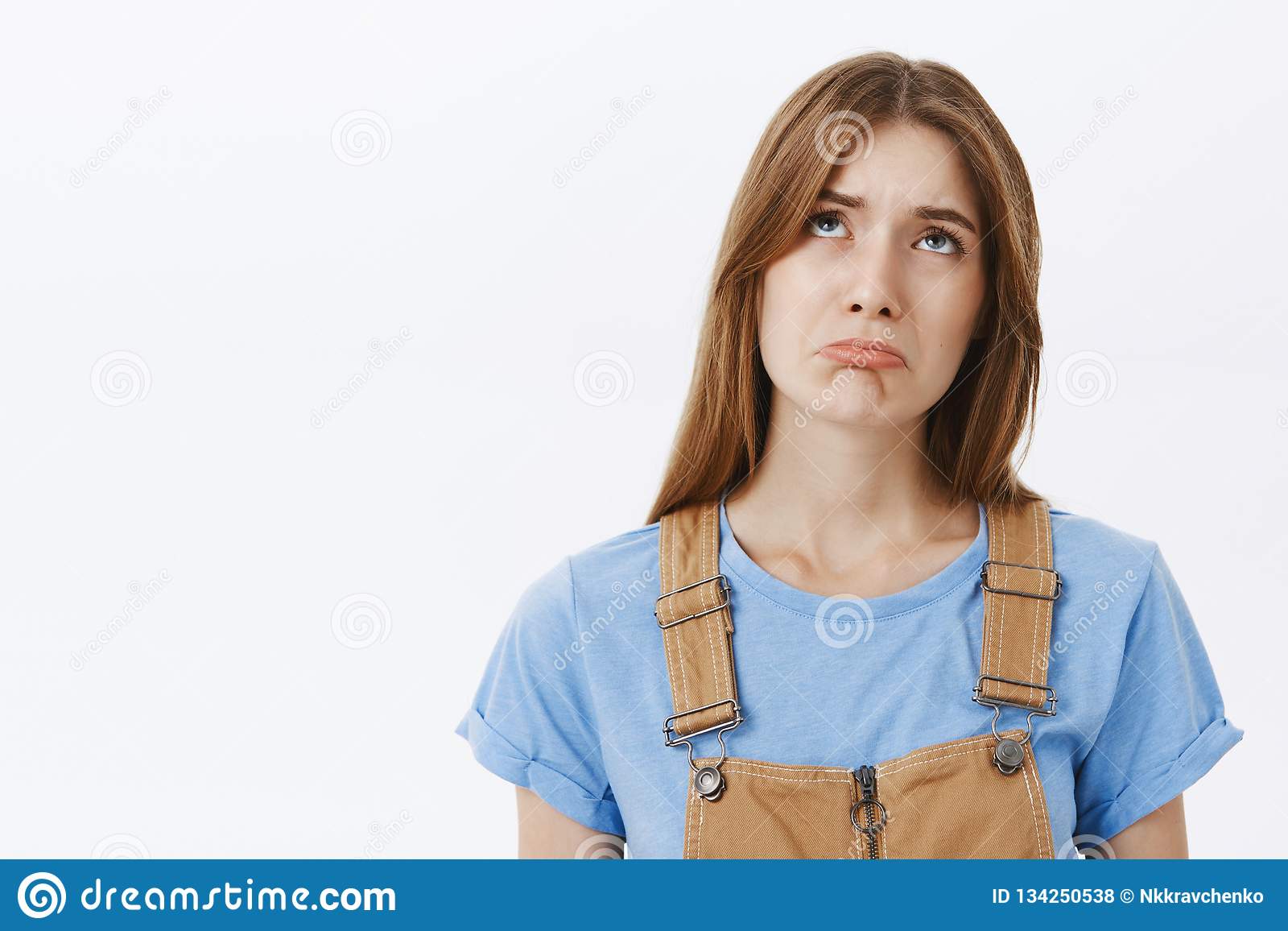 waist-up-shot-envious-gloomy-sad-cute-girl-brown-hair-overalls-blue-t-shirt-making-unhappy-smile-waist-up-shot-134250538.jpg