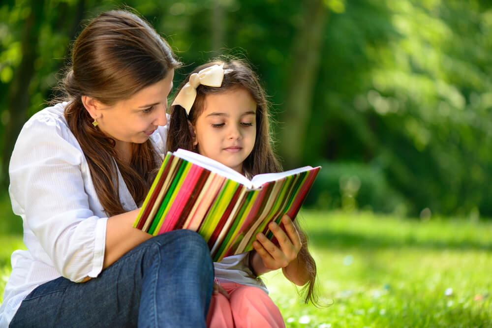 madre-e-hija-leen-un-libro-al-aire-libre-para-motivar-a-la-lectura.jpg