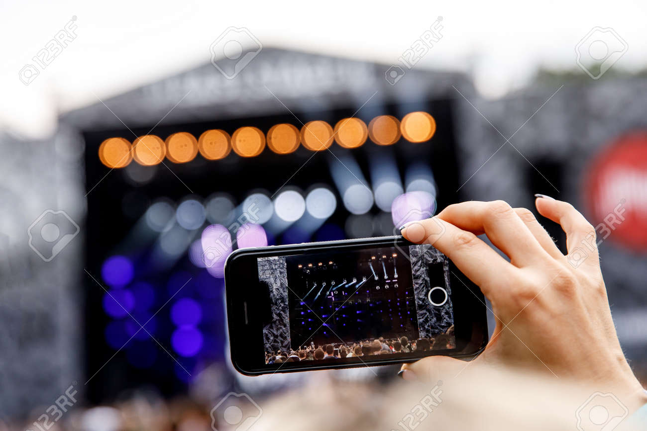 129484651-recording-a-concert-on-a-mobile-phone-outdoor-stage.jpg