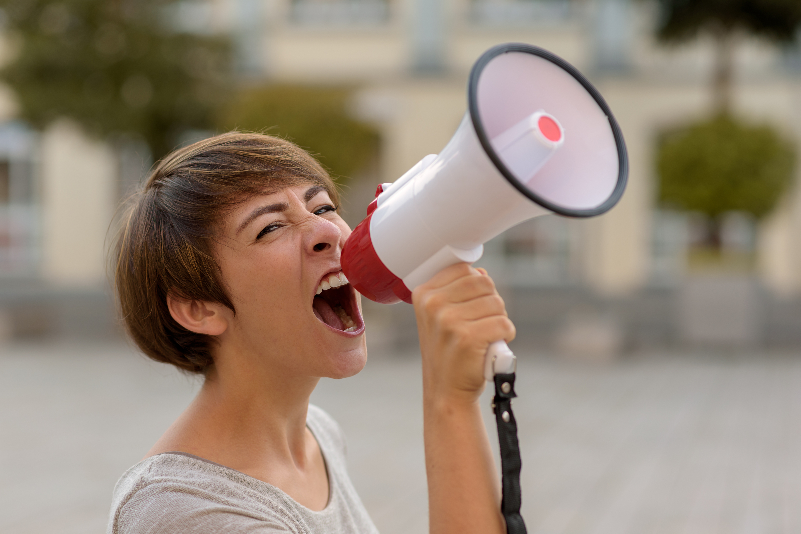 young-woman-yelling-into-a-megaphone-or-bullhorn-58947006.jpg