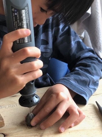 Boy drilling a gumnut