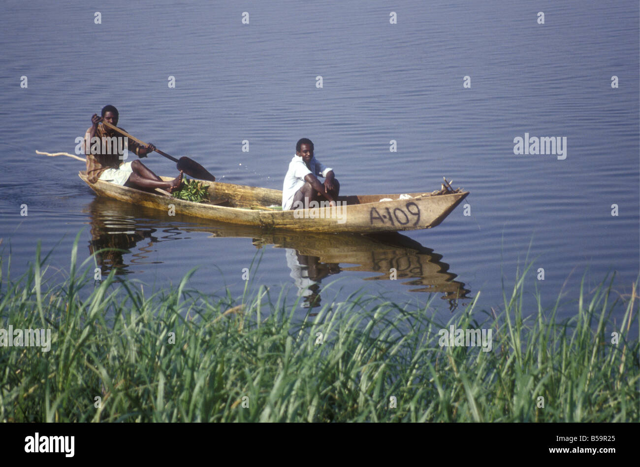 two-black-african-men-fishermen-paddling-their-wooden-dug-out-canoe-B59R25.jpg
